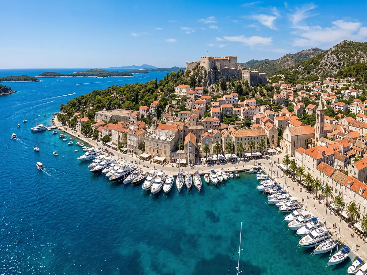 Hvar Town harbour with yachts and the fortress above